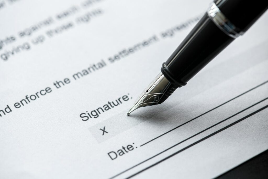 Close-up of a pen signing a legal document for divorce or separation.