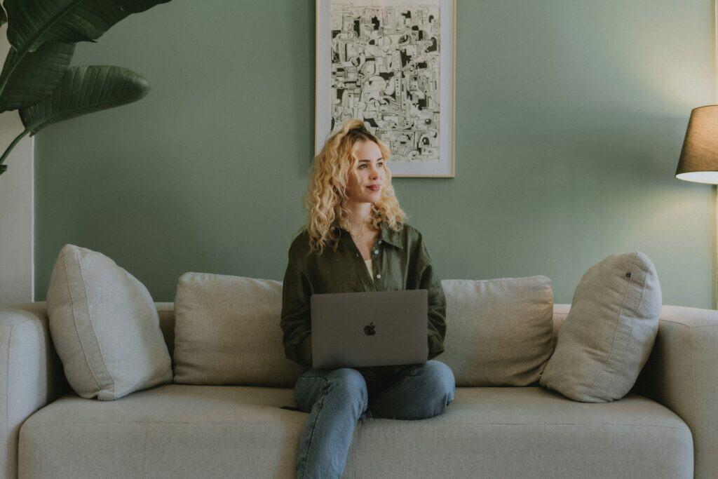 Woman with laptop on sofa in modern living room for family law.