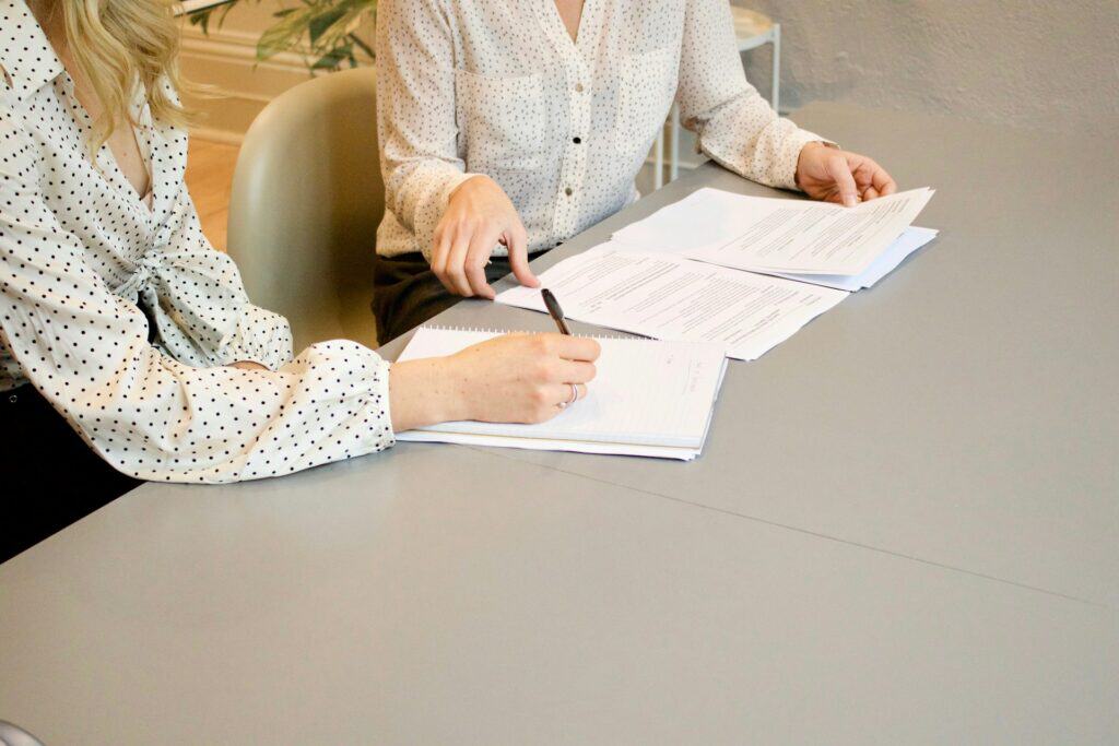 Two women discussing documents during a mediation session.